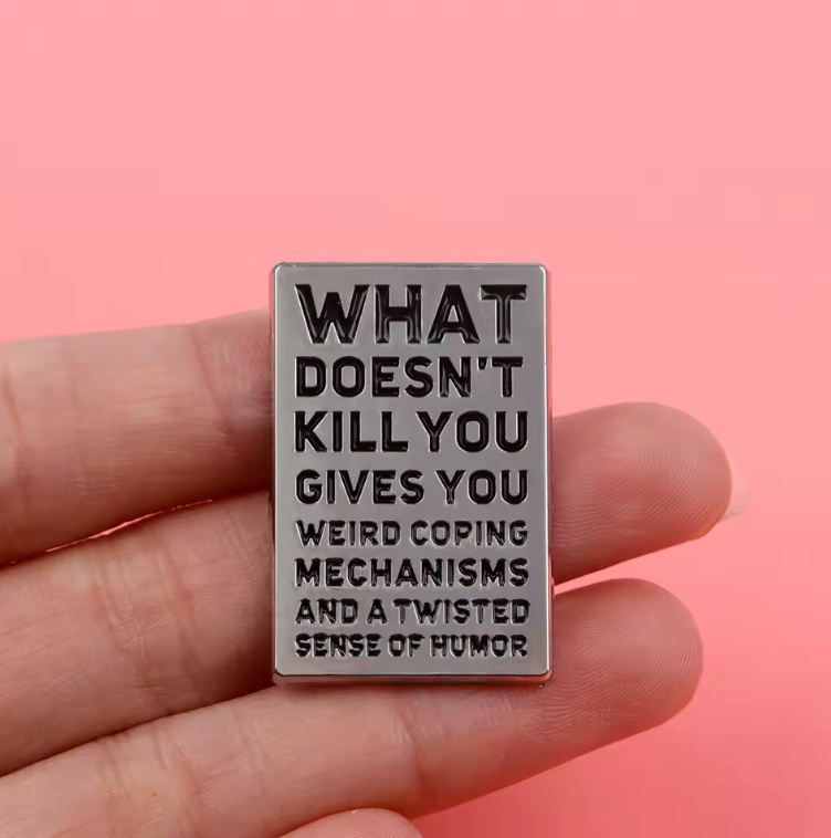 WHAT DOESN'T KILL YOU GIVES YOU AN UNHEALTHY SET OF COPING MECHANISMS AND A DARK SENSE OF HUMOR ENAMEL PIN